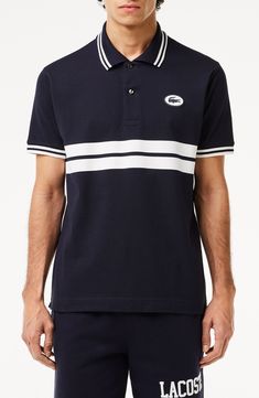 Sporty and French-inspired, this classic-fit polo features placed stripes, tipped edges and a silicone logo at the chest for iconic Lacoste style. 28" length Button half placket Spread collar Short sleeves 100% cotton Hand wash, line dry Imported Cotton Polo Shirt With Three Stripes Branding, Classic Polo Shirt With Contrast Stripes, Classic Polo Shirt With Signature Stripes, Classic Collared Polo Shirt With Signature Stripes, Classic Three-stripes Polo Shirt, Classic Three Stripes Polo Shirt, Classic Polo Shirt With Striped Collar For Golf, Casual Golf Polo Shirt With Contrast Stripes, Casual Polo Shirt With Contrast Stripes For Golf