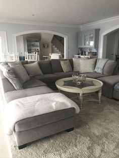 a living room with gray couches and white rugs on the floor in front of a fireplace