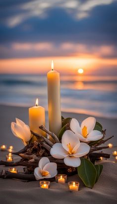 candles and flowers on the beach at sunset