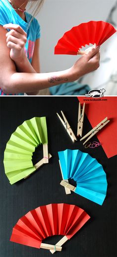 a girl is holding some paper fans and making them look like they have been folded up