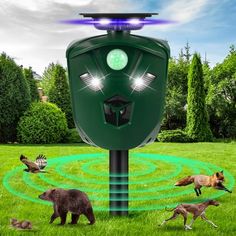 an electronic device in the middle of a grassy field with animals around it and lights on