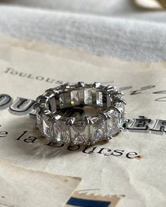 Get your sparkle on with the Rêvasser Ring—a diamond eternity ring to make all your friends say “ooh-la-la”! Strut about town in that subtle-but-glamorous way you do, and bask in the compliments this dazzling piece of jewelry will bring you. Rêvasser Ring means Daydream in French. This dreamy stackable ring is prefect to add to your collection. Cubic Zirconia 4x6mm set in silver. White Gold Emerald Cut Eternity Band, Cubic Zirconia Emerald Cut Half Eternity Ring, Cubic Zirconia Radiant Cut Half Eternity Jewelry, Emerald Cut Cubic Zirconia Half Eternity Ring, Silver Jewelry With Half Eternity Baguette Cut, Gift Emerald Cut Eternity Band With Prong Setting, Emerald Cut Eternity Band With Prong Setting Gift, Diamond White Half Eternity Emerald Cut Jewelry, Radiant Cut Cubic Zirconia Half Eternity Ring