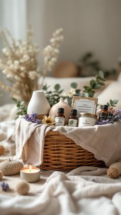 a wicker basket filled with body care products on a bed next to flowers and candles