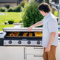 a man standing in front of an outdoor bbq grill with food cooking on it