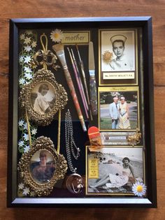 a shadow box filled with pictures and other items on top of a wooden table next to a pen