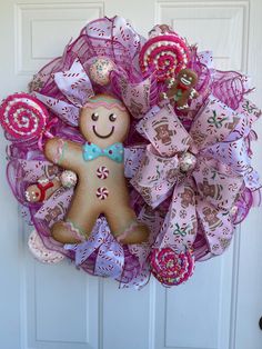 a wreath with a gingerbread man and candy canes hanging on the front door