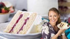 a woman holding a slice of cake in front of a plate with berries on it