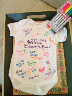 a baby's welcome home shirt and crayons in a box