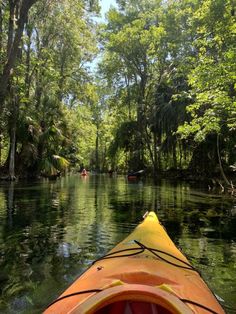 a kayak in the middle of a river surrounded by trees