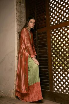 DETAILS Front open jacket, diagonal pleated bodice and attached skirt with hand-embroidered motifs. Inner contrasting shirt with an organza scalloped hem, hand-embroidered. Paired with a two-toned, crushed, two part lehnga. COLOR Coral / Green SIZE Custom Order - A measurement guide will be sent upon order. Model is 5'7 MATERIAL Jacket - Sheesha SilkShirt - Raw Silk / Silk OrganzaLehnga - Khaddi Silk PRODUCT CODE 300000-08-26 PRODUCT OF PAKISTAN GARMENT CARE Handle With Care Professionally Dry C Festive Fitted Salwar Kameez With Embroidered Sleeves, Elegant Chanderi Traditional Wear With Embroidered Sleeves, Wedding Sharara For Eid With Embroidered Sleeves, Traditional Cotton Silk Dress With Embroidered Sleeves, Fitted Chanderi Set With Embroidered Sleeves, Fitted Salwar Kameez With Embroidered Sleeves For Designer Wear, Designer Fitted Salwar Kameez With Embroidered Sleeves, Front Open Silk Set With Dupatta, Silk Front Open Sets With Dupatta