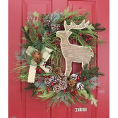 a christmas wreath on a red door with pine cones, evergreens and a deer