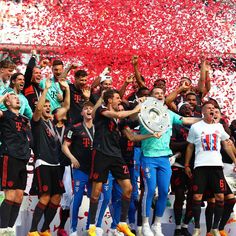 the soccer team is celebrating with their trophy and confetti in front of them