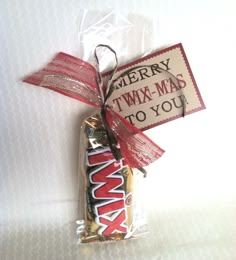 a candy bar wrapped in red and white paper with a tag that says merry twx - mad to you