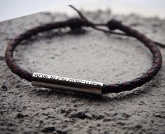 a leather bracelet with an engraved bar on it