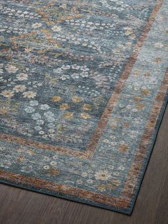 a blue rug with flowers on it in the middle of a wooden flooring area