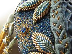 a close up view of some beads on a piece of cloth with gold and blue accents