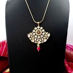 Beautiful high quality ruby kundan pendant and earrings with pave crystal accents. Just the right size - not too big, not too small. Very sparkly and eye-catching. Beautiful meenakari enamel work on reverse of pendant and earrings. This is a substantial, heavy piece. Pendant: Length 3 in. Width 2 1/2 in. Earrings: Length 1 1/2 in. Width 1 3/4 in. Weight 7 gm. Light and comfortable to wear. Shop more amazing necklaces: https://www.etsy.com/shop/boutiquebymaryam/?section_id=32674452 Be sure to vis Meenakari Pendant Jewelry For Puja, Traditional Gold Plated Kundan Pendant Necklace, Traditional Gold-plated Kundan Pendant Necklace, Temple Jewelry With Meenakari Round Pendant, Traditional Gold Plated Pearl Pendant Jewelry, Meenakari Temple Jewelry Round Pendant, Meenakari Round Pendant Temple Jewelry, Festive Kundan Temple Jewelry Necklace With Round Pendant, Gold Plated Meenakari Pendant Necklace