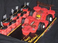 a birthday cake made to look like a race car with cupcakes in the shape of cars