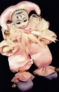 a doll is dressed in pink and white