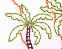 an embroidered palm tree with orange and green trim