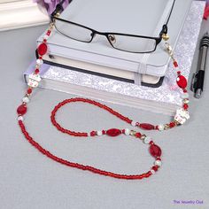 Our red and white, gold eyeglass chain is perfect for preventing your reading glasses from ever being misplaced again. Featuring cute ceramic lucky cat beads. The perfect gift for a loved one. Rubber loops adjust to fit most glasses frames. Lightweight and comfortable fit.   🦉Product Details:  * Approx. Length - 30 in (including rubber loops) * Chain Weight: 1 oz * Bead Color(s): Red, White, Gold * Metal Color: Gold-tone * Material: 15 mm Lucky Cat Beads, Acrylic and Glass Beads * Closure: Lobster Claw Clasps and Rubber Loop Ends * Product ID: G596 🎁 Gift packaging available at Checkout ($4.00 USD) - See last image   🦉NOTES: * Not recommended for young children! * The lobster clasps make replacement of the rubber loops easy if they break. * All measurements and weights are approximate a White Glasses Chain With Lobster Clasp For Gift, Red Beaded Glasses Chains As Gift, Red Beaded Glasses Chains For Gift, Red Glass Glasses Chains As A Gift, Red Glass Glasses Chains For Gift, Adjustable Red Glass Glasses Chains, Cat Beads, Beaded Eyeglass Chain, Glasses Chains