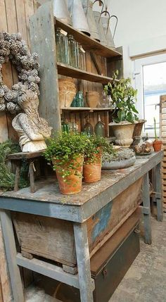 an old wooden table topped with potted plants