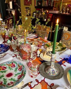 the table is set with plates, candles and other decorative items for dinner party guests