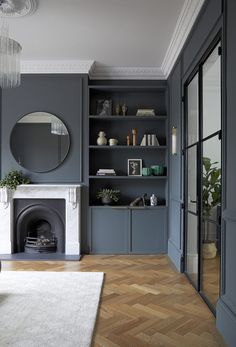 a living room filled with furniture and a fire place in front of a mirror on the wall