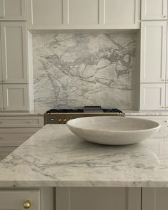 a white bowl sitting on top of a counter in a kitchen next to an oven