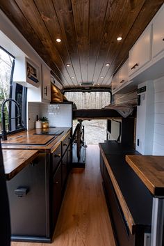 the interior of an rv with wood flooring and white walls, along with black counter tops