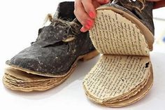 a woman is holding onto an old pair of shoes that have been turned into books