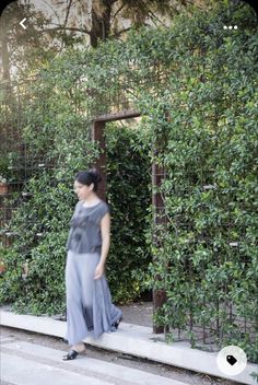 a woman in grey dress walking down steps