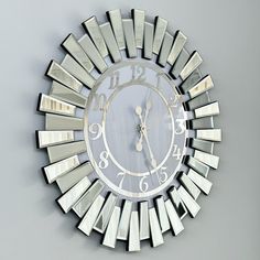 a large mirror clock with roman numerals on the face