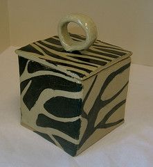 a zebra print box with a white ring on it's handle sitting on a table