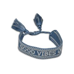 a blue headband with the words good vibes on it and two tassels attached