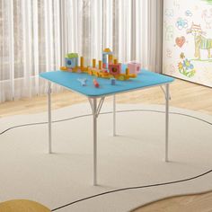 a child's play table with toys on it in front of a curtained window