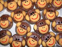 there are many cupcakes that have faces on them and monkey heads in the middle