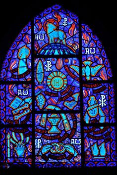 a large stained glass window with symbols on it's sides and letters in the middle