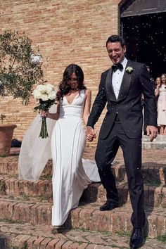 a bride and groom are walking down the steps