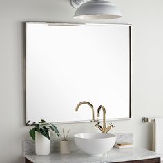 a bathroom vanity with a large mirror above it and a bowl sink below the mirror