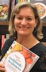 a woman holding a cookbook in her hands