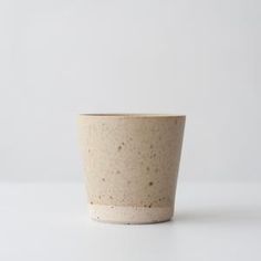 a pink cup sitting on top of a white table