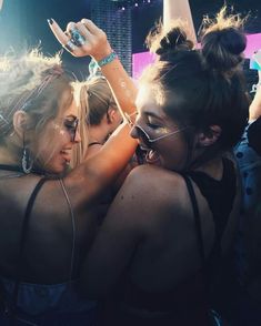 two girls are hugging each other at a concert