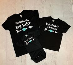 "Set of 3 personalized matching sibling shirts! (wording can be changed, big, middle, sister etc..) Shown in black shirts with aqua accents (names can be added under the arrow to match the heart) This set shown says Professional big sister, big brother in training, newest addition. Add one shirt at a time to your cart and purchase all together to make your perfect set! These are adorable to welcome a new baby into the family! Makes a sweet personalized gift for a mom with her 3rd child! They als Black T-shirt With Name Print For Parenting, Black Family Matching T-shirt For Gender Reveal, Personalized Black Cotton T-shirt, Fitted T-shirt For Family Matching Gift, Customizable Matching T-shirt For Family, Customizable Matching Family T-shirt, Personalized Black T-shirt For Family Matching, Matching Customizable T-shirts For Family, Black Top With Name Print For Gender Reveal