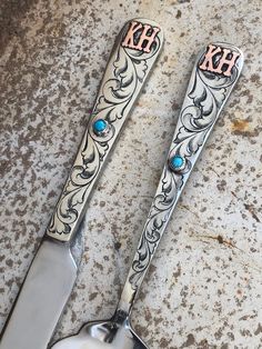 two spoons with monogrammed designs on them sitting next to each other,