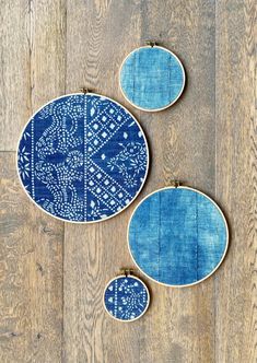 three blue plates sitting on top of a wooden floor