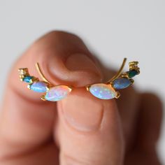 -18kt gold vermeil -lab created blue opal ombre stones  Earrings with a unique twist. These gorgeous colorful ear climbers are dainty but they are also striking and eye-catching. Made up of a mix of pastel colored opal hues. To extend the life of your gold plated and vermeil jewelry, avoid wearing when washing hands, showering, applying lotion, using harsh cleaning supplies or working out. To clean, buff gently with a soft and dry 100% cotton cloth or a microfiber cloth. Do not use jewelry cleaner on gold plated jewelry. Fire Opal Jewelry, Tennis Jewelry, Stones Earrings, Fire Opals Jewelry, Ear Climbers, Solid Gold Earrings, Forever Jewelry, Vermeil Jewelry, Jewelry Ring Box