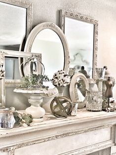 a mantle with mirrors, vases and other decorative items on it in a living room