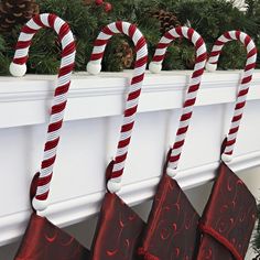 three candy canes hanging from a mantel