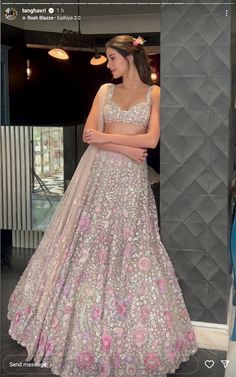 a woman in a pink and silver gown standing next to a mannequin wearing a flowered dress